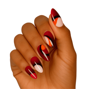 Hand wearing red and orange abstract gel nail wraps with glossy finish