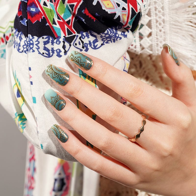 Green jade gel nail wraps with gold mandala patterns on hand