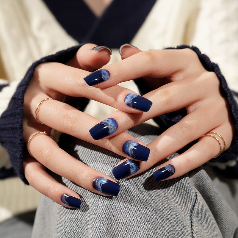 Dark blue ombre gel nail manicure on hands showing moody storm design