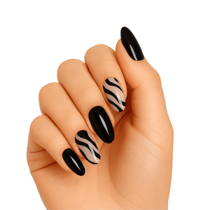 Hand wearing black and white diagonal striped gel nail wraps with glossy black accent nails