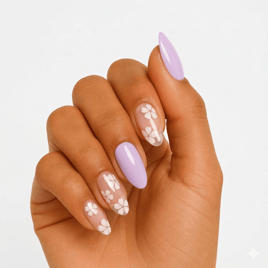 Lilac gel nail wraps with white floral patterns on hand showing spring nail art