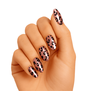 Hand displaying rose gold leopard print gel nails with black spots animal design